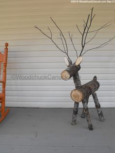 a wooden rocking chair sitting next to a fake deer