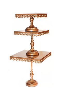 three tiered gold metal cake stand on white background