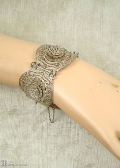 "(Description is below) ALL DELIVERY DATES mentioned by Etsy are ESTIMATES, no delivery date or range is guaranteed, though most of our orders arrive ahead of estimate.  LAYAWAY IS AVAILABLE, typically with a 20% deposit. Please contact us to arrange.  Big antique bracelet, ornate dimensional Etruscan silver (900, tested) filigree panels, original fine silver safety chain, box tab clasp. Measures just over 7.75\" with the clasp closed. Condition is excellent with age appropriate wear.  As with a Ornate Antique Silver Jewelry For Festival, Victorian Sterling Silver Bracelet For Wedding, Ornate Filigree Jewelry For Festival, Vintage Sterling Silver Wedding Bracelet, Victorian Sterling Silver Wedding Bracelet, Ornate Silver Bracelets For Festivals, Vintage Sterling Silver Bracelet With Intricate Design For Wedding, Nickel-free Vintage Jewelry For Festive Occasions, Vintage Nickel-free Jewelry For Festive Occasion