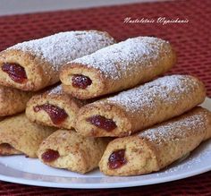 a white plate topped with pastries covered in powdered sugar