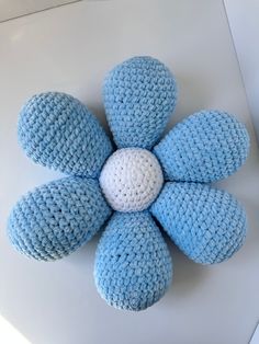 a crocheted blue and white flower sitting on top of a table