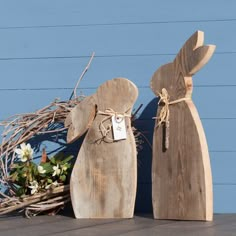 two wooden rabbits are sitting next to each other