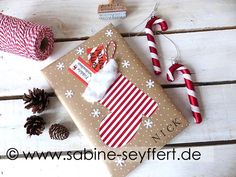 a wrapped present sitting on top of a wooden table next to twine of twine