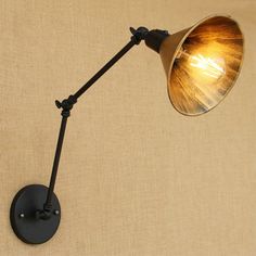 an old fashioned wall lamp with a light bulb on it's arm, against a beige background