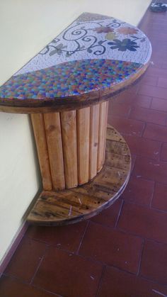 a wooden bench sitting on the side of a wall next to a red brick floor