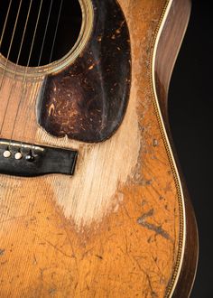 an old guitar is sitting on the floor