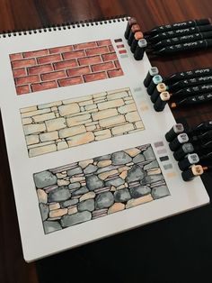 several different colored pencils sitting on top of a table next to a drawing book