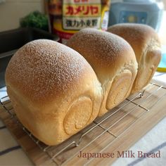 three loaves of bread sitting on a cooling rack