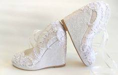 two pairs of white bridal shoes with lace on the bottom and bows at the side