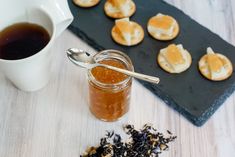 a jar filled with honey next to tea and cookies