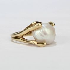 A fine, modernist 14k yellow gold and baroque pearl cocktail ring from the mid-20th century.  Features a large baroque pearl in an organic, pronged setting.  Interior of shank stamped: 14K   Overall Width: ca. 3/4 in. Ring size: 6 1/4  Pearl size:  Ca. 11mm x 13mm    Dimensions reference the ring size and are not specific to the ring itself. Baroque Pearl Engagement Ring, Baroque Pearl Ring, Big Ring Designs, Pearl Rings In Gold, Baroque Ring, Wed Rings, Pearl Gold Ring, Pearl Ring Gold, Pearls Ring