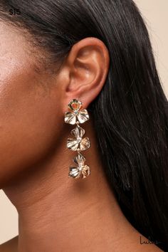 The Lulus Glowing Charm Gold Rhinestone Flower Drop Earrings are ready to capture everyone's attention and get the compliments started! Shiny gold-toned metal shapes these statement-making earrings that feature a series of flowers (with dainty rhinestone details at the centers) that cascade down the drop-style silhouette. Post backs. Earring measures 2. 5" Long. 90% Iron, 10% Stone. Imported. Lulus | Glowing Charm Gold Rhinestone Flower Drop Earrings. Gold Flower-shaped Earrings For Formal Events, Yellow Gold Flower-shaped Clip-on Earrings For Formal Events, Gold Cubic Zirconia Dangle Flower Earrings, Gold Clip-on Drop Flower Earrings, Elegant Flower-shaped Earrings With Rhinestones, Flower Drop Earrings, Rhinestone Flower, Lulu Fashion, Making Earrings