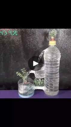 a plastic water bottle is being filled with water and surrounded by two small vases