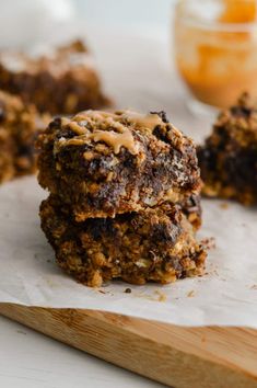 three cookies stacked on top of each other with peanut butter and chocolate chips in the background