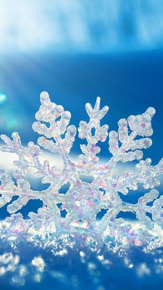 a snowflake is sitting on the ground in front of some blue and white lights