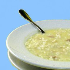 a white bowl filled with soup and two spoons