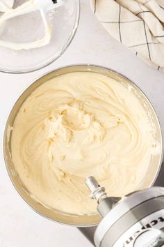 a mixing bowl filled with batter next to an electric hand mixer on a white counter