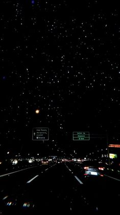 the night sky is filled with stars and street signs