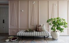 a living room with pink walls and decorative art on the wall, including a bench