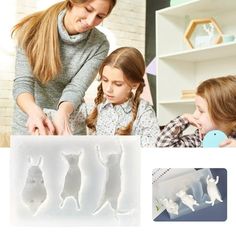 two girls and one girl are playing with plastic animals in front of a book shelf