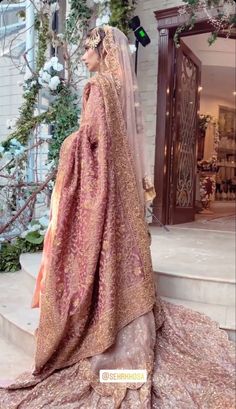 a woman in a wedding dress is standing on the steps with her veil over her head