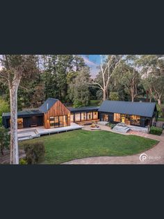 an aerial view of a house in the middle of a park with trees and grass