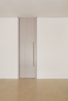 an empty room with white walls and wooden floors