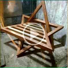 a wooden star sitting on top of a cement floor in front of a wall with a green frame