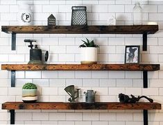 three wooden shelves with pots and plants on them against a white tiled wall in a kitchen