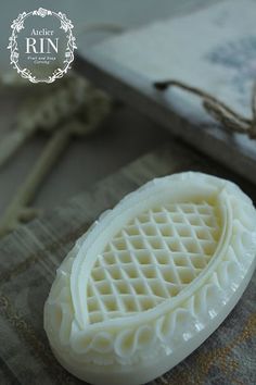 a soap bar sitting on top of a piece of wax paper next to a book