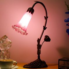 a lamp that is on top of a table next to a cup and saucer