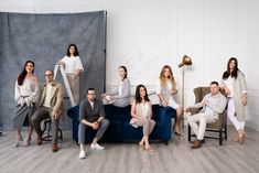 a group of people sitting on top of a blue couch in front of a wall