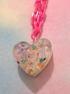 This is a handmade epoxy resin necklace with a plastic 50cm chain in iridescent pink. The charm is approximately 3.5 cm wide. This is an adorable necklace that would fit with a range of outfits and styles. It features many small pastel charms and lots of holographic glitter to catch the eye! The backing is holographic lilac. Each item is one of a kind and handmade - so each one is completely unique and special! Decora Style, Epoxy Resin Necklace, Resin Necklace, Holographic Glitter, Lucky Girl, Epoxy Resin, Halloween Shopping, Charm Necklace, Heart Shapes