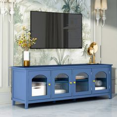 a blue entertainment center with two glass doors and a flat screen tv mounted on the wall