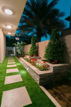 an outdoor garden with artificial grass and flowers in the planter boxes on either side