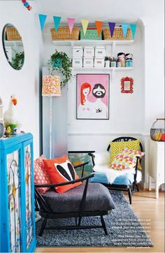 a living room filled with furniture and pictures on the wall next to a blue cabinet