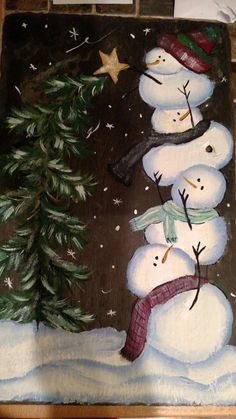 a painting of three snowmen in front of a christmas tree