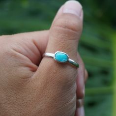 Make a big statement with this sleek mini ring! It's lightweight and dainty, featuring a stunning turquoise center stone nestled in a sterling silver setting. Stack it on to your finger and brighten up any outfit! Adjustable Turquoise Ring For Everyday Wear, Minimalist Adjustable Turquoise Ring For Everyday, Minimalist Sterling Silver Turquoise Promise Ring, Everyday Sterling Silver Turquoise Ring, Minimalist Silver Turquoise Promise Ring, Minimalist Turquoise Ring For Everyday, Everyday Turquoise Ring With Gemstone, Everyday Turquoise Gemstone Ring, Minimalist Open Turquoise Ring