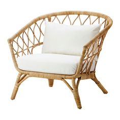 a wicker chair with white pillows on it