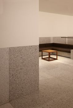 an empty room with concrete walls and benches