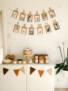 a table topped with cake and pictures hanging on the wall