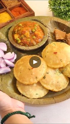 a person is holding a plate with food on it and there are other foods in the background