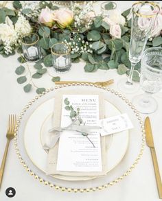 a table set with place settings and flowers