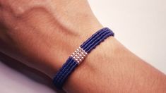 a person's arm with a blue bracelet on it and a diamond clasp around the wrist