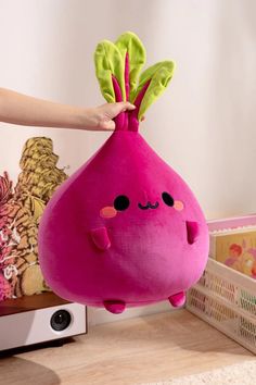 a pink stuffed animal with green leaves on it's head