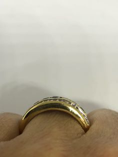 a person's hand with a gold ring on it