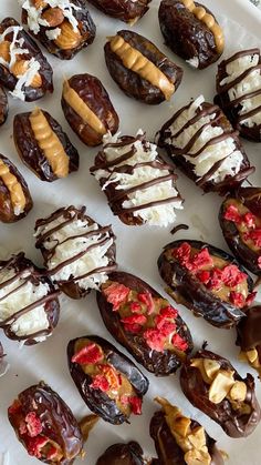 chocolate covered doughnuts with white and red toppings are arranged on a platter