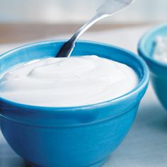 a blue bowl filled with yogurt and a spoon