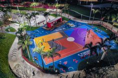 an aerial view of a basketball court in the middle of a park with palm trees