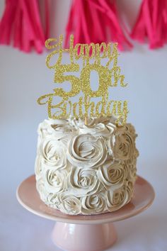 a birthday cake with white frosting and gold sparklers on top that says happy 50th